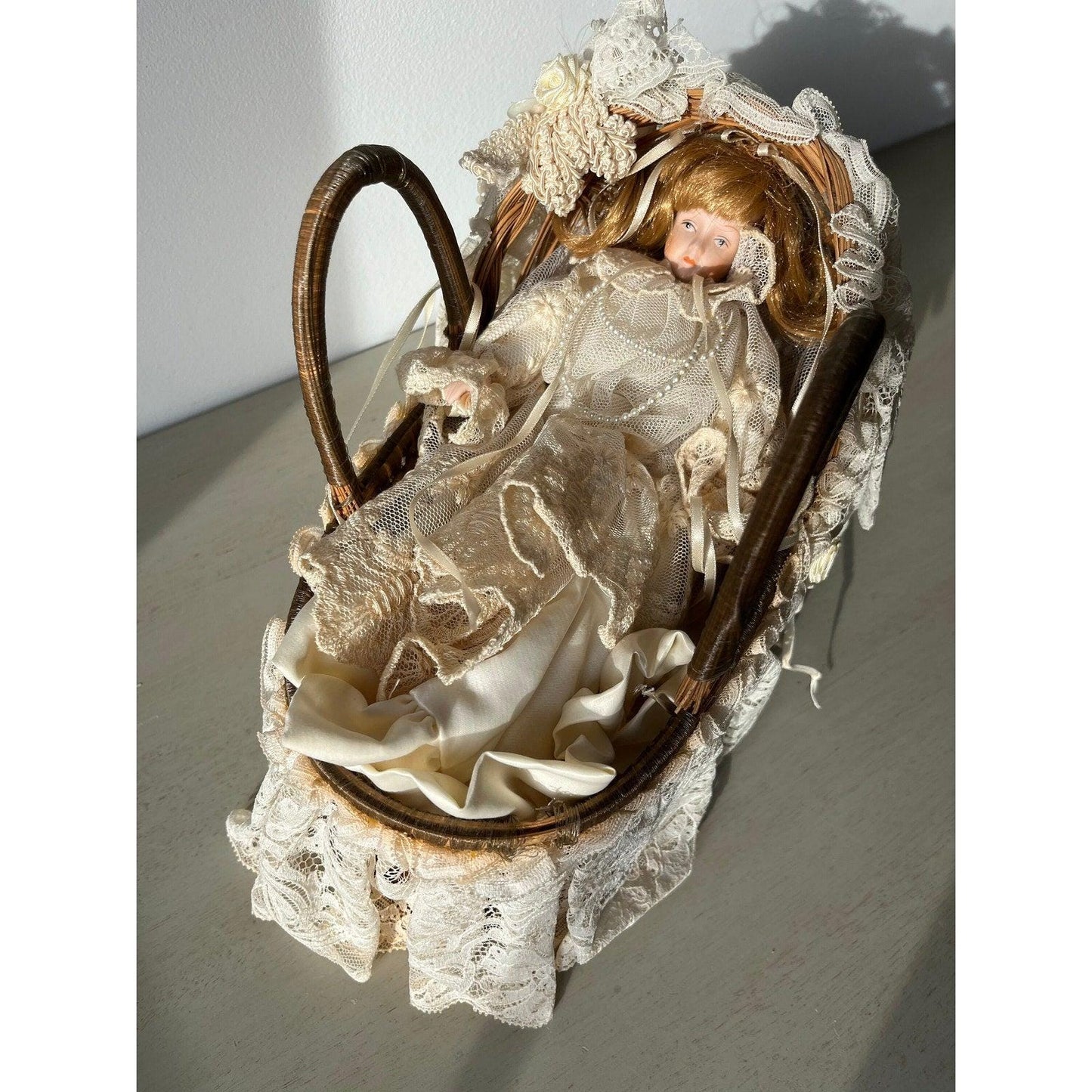 Vintage doll in a wicker basket with lace