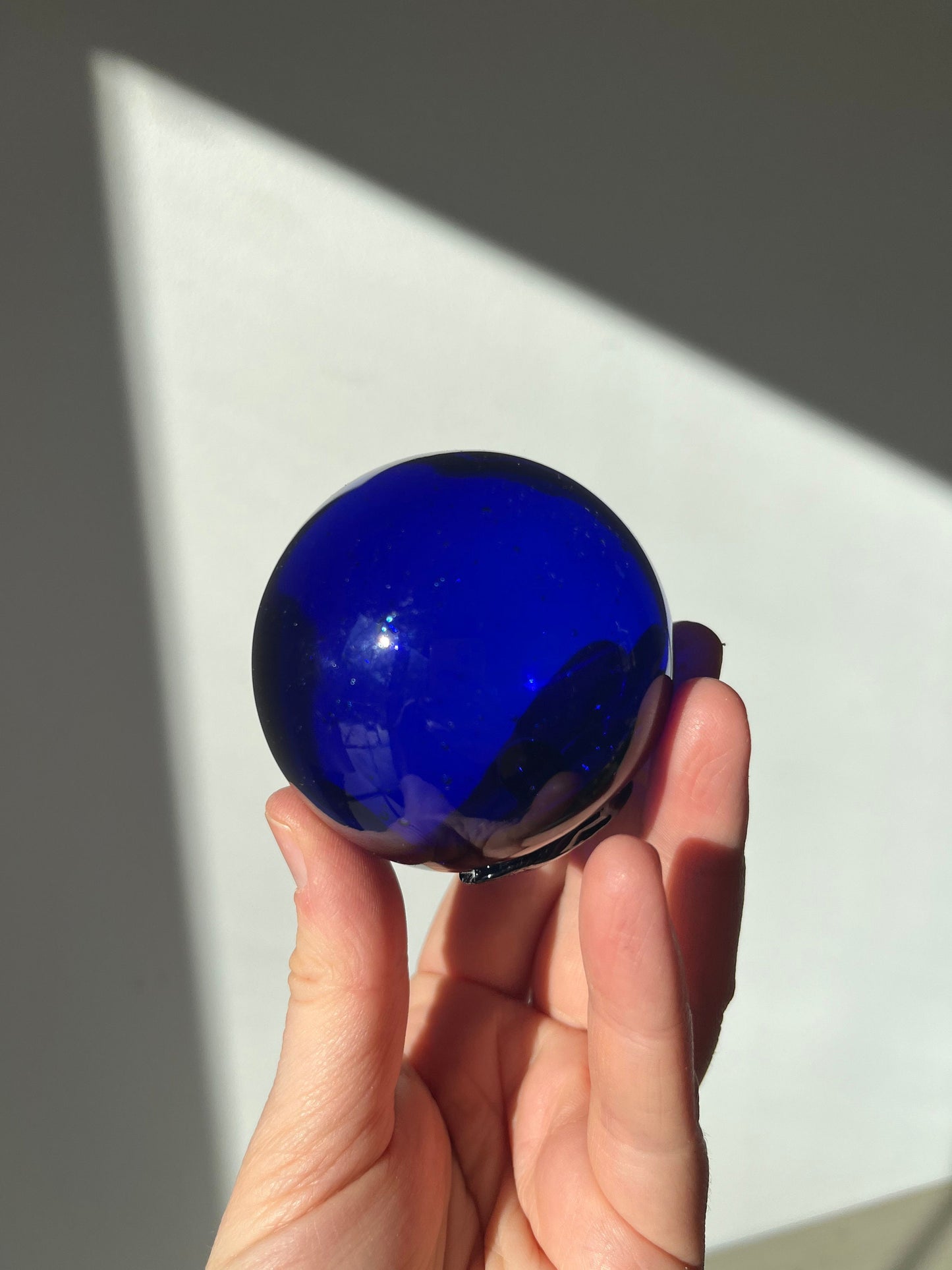 Vintage cobalt blue glass ball on a metal fish sculpture stand