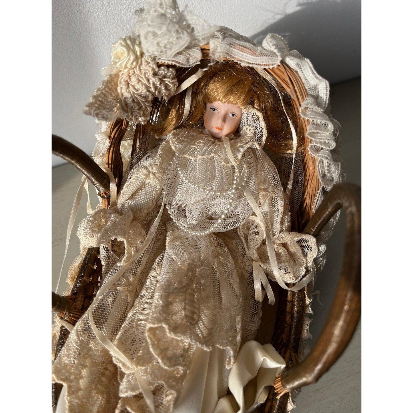 Vintage doll in a wicker basket with lace